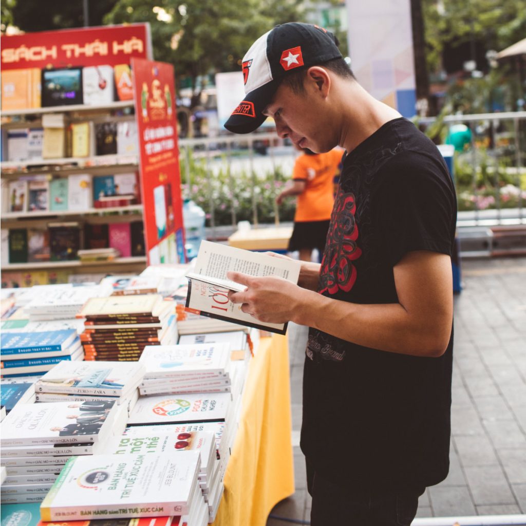 photo of a man reading at a table of books